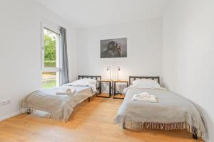 een slaapkamer met 2 bedden en een raam bij Großzügiges Business Apartment Herrenberg - Self Check-In in Herrenberg