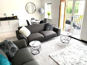 sala de estar con sofá y 2 mesas en Mill Bank Apartment, en Todmorden