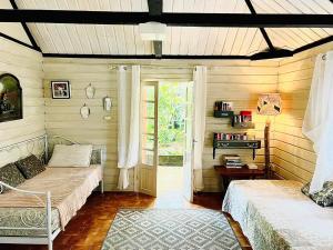 a bedroom with two beds and a door to a yard at La Kaz LANGEVIN in Saint-Joseph