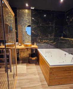 a bathroom with a bath tub and a sink at Loft & spa d'Autan in Villefranche-de-Lauragais