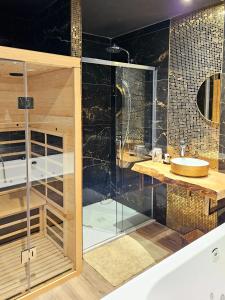ein Bad mit einer Glasdusche und einem Waschbecken in der Unterkunft Loft & spa d'Autan in Villefranche-de-Lauragais
