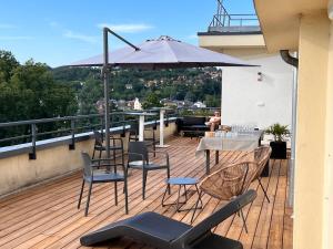 een balkon met een tafel en stoelen en een parasol bij Hotel Le Quercy - Sure Hotel Collection by Best Western in Brive-la-Gaillarde