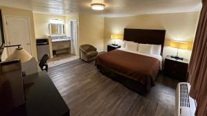 a hotel room with a bed and a bathroom at Relax Inn of Medford in Medford