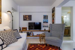 a living room with a couch and a chair and a tv at To Myrmigki in Skopelos Town