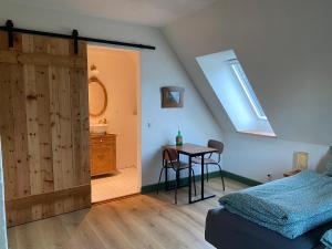 Schlafzimmer mit einem Bett, einem Tisch und einem Fenster in der Unterkunft Gamle Præstegård in Fåborg