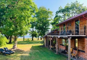 a log house with a deck and a porch at Sea Side Kaltene in Kaltene