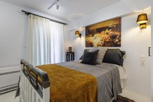 a bedroom with a bed and a painting on the wall at To Myrmigki in Skopelos Town