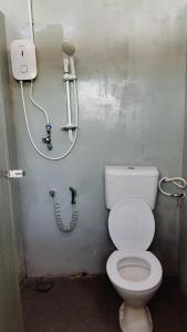 a bathroom with a white toilet and a hose at Rustika Glamping in Kampong Tanjong Che Lahom