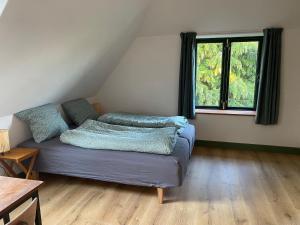 ein Zimmer mit einem Bett mit Kissen darauf in der Unterkunft Gamle Præstegård in Fåborg