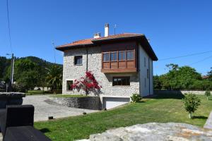 a white brick house with a wooden roof at Villa El Martín in Naves