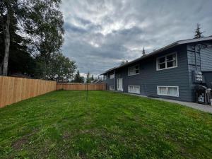 einen Hof vor einem Haus mit einem Zaun in der Unterkunft Anchorage midtown apartment- Wyoming 1 in Anchorage
