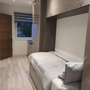 1 dormitorio con cama y ventana en 64 Salmon Street en Londres