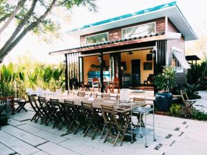 a table and chairs in front of a house at โรงแรมบ้านเพิ่มสุข อิมแพ็ค เมืองทอง in Pak Kret