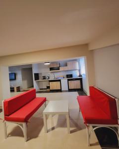 a living room with two red chairs and a table at Нашата къща "our house" in Pomorie