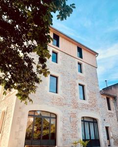 ein großes Backsteingebäude mit einem großen Fenster in der Unterkunft La Bellours Chambre D'Hôtes in Cahors