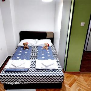 two teddy bears sitting on a bed in a room at Apartman PAVLE in Pluzine