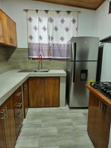 a kitchen with a stainless steel refrigerator and a window at Suite amoblada en Santa Cruz in Puerto Ayora