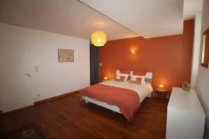 Un dormitorio con una cama grande con paredes naranjas. en Hypercentre (avec parking), rare avec 3 chambres 3 salles d’eau, en Albi