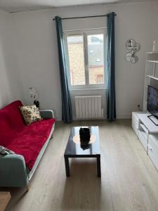 un soggiorno con divano rosso e tavolino da caffè di Chez Laeti appartement type F2 a Fécamp