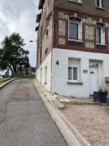 an empty street next to a brick building at Chez Laeti appartement type F2 in Fécamp +14 photos
