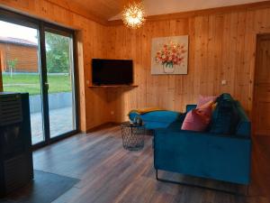 a living room with a blue couch and a television at Vogelsberger Zirbenstüberl in Grebenhain