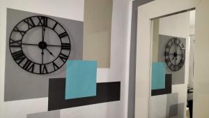 un orologio su un muro accanto a uno specchio di ROMA HOME a Trento