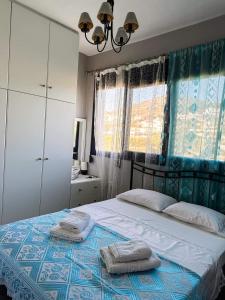 a bedroom with a bed with two towels on it at Leros Sunset Apartments in Gourna