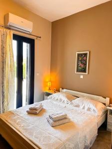 a bedroom with a bed with two towels on it at Leros Sunset Apartments in Gourna