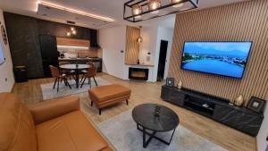a living room with a couch and a flat screen tv at Relax House NS in Novi Sad