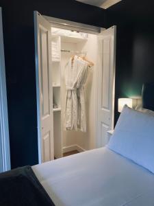 a bedroom with a white bed and a closet at The Smiling Frog in Portchester