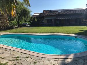 una piscina con acqua blu di fronte a una casa di IL SALICE a Novara