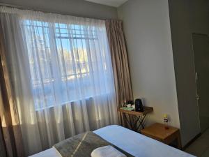 sypialnia z łóżkiem i dużym oknem w obiekcie Green Grove Villa Doringkloof w mieście Centurion
