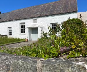 une maison blanche avec un jardin en face dans l'établissement The Old Chapel, à Saint David's