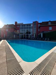 a large swimming pool in front of a building at Douro Marina Hotel & SPA in Resende