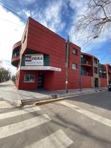 a red building on the corner of a street at Elegante departamento en Mendoza in Mendoza