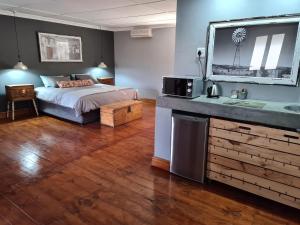 a bedroom with a bed and a sink in it at Avondrust Guest House in Klaarstroom