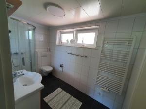 a bathroom with a sink and a toilet and a window at Caron in Ording