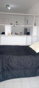 1 dormitorio con cama y estanterías blancas en La Recova de La Boca en Buenos Aires
