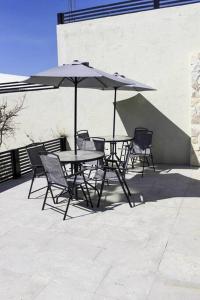 uma mesa e cadeiras com um guarda-sol num pátio em Habitación 23 - Green Casitas em Ensenada