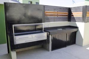 uma cozinha com um grelhador com fumo a sair dele em Habitación 23 - Green Casitas em Ensenada