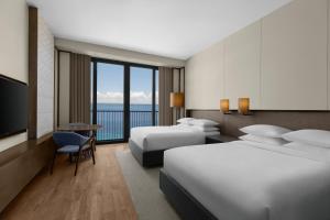 a hotel room with two beds and a television at Sheraton Cebu Mactan Resort in Mactan