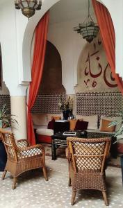 een woonkamer met een bank en een tafel en stoelen bij Riad Nirvana in Marrakesh