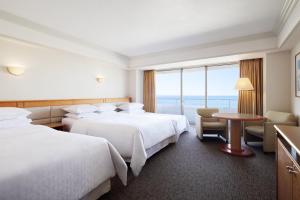 a hotel room with two beds and a table at Sheraton Grande Tokyo Bay Hotel in Urayasu