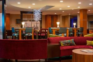 a restaurant with red couches and tables and chairs at SpringHill Suites by Marriott Corpus Christi in Corpus Christi