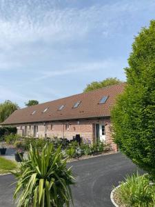 a brick building with a roof with skylights on it at 2 Gîtes 5 chambres in Blaringhem