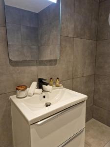 La salle de bains est pourvue d'un lavabo blanc et d'un miroir. dans l'établissement Lorans, à Perstorp