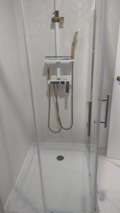 a shower with a hose in a bathroom at flor hostel capsules in Madrid