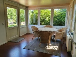 a dining room with a table and chairs and windows at Caron in Böhl