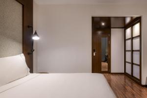 a bedroom with a large white bed and a hallway at AC Hotel by Marriott Alicante in Alicante