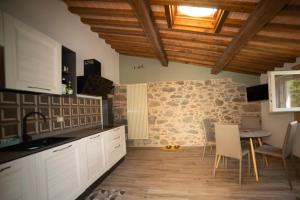a kitchen with a table and a stone wall at Casa vacanze Raggio di Sole in Grotte